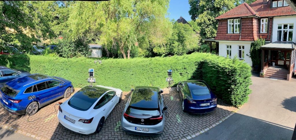 Blick auf den Parkplatz vor dem Witzenhausen-Institut: vier Elektroautos und zwei Ladesäulen